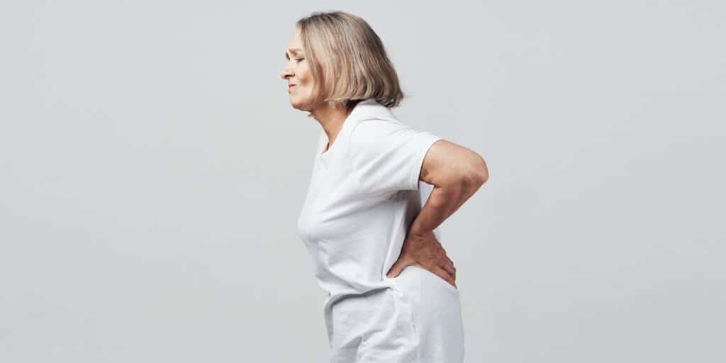 Mulher de meia idade com dores nas costas por reumatismo site Dr. Marcelo Corrêa reumatologista Belém - PA