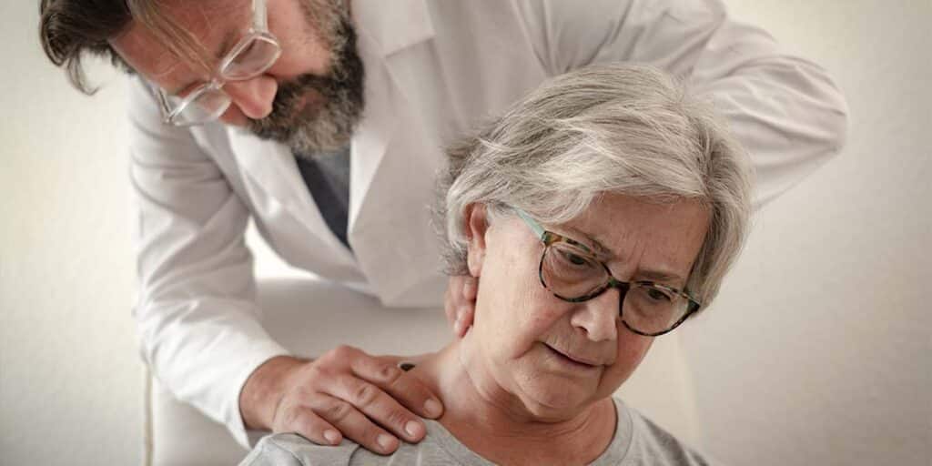 Reumatologista examinando pescoço de senhora com dor nas costas - Dr. Marcelo José Uchoa Corrêa Reumatologista de Belém - PA